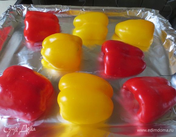 Перец разрезаем пополам, удаляем сердцевину, кожей наружу выкладываем на застеленный фольгой противень.