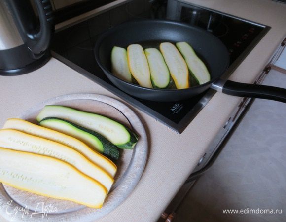 Цукини режем на тонкие полоски (0,5 см), обжариваем только с одной стороны на оливковом масле и выкладываем на салфетку. Посолить и поперчить.