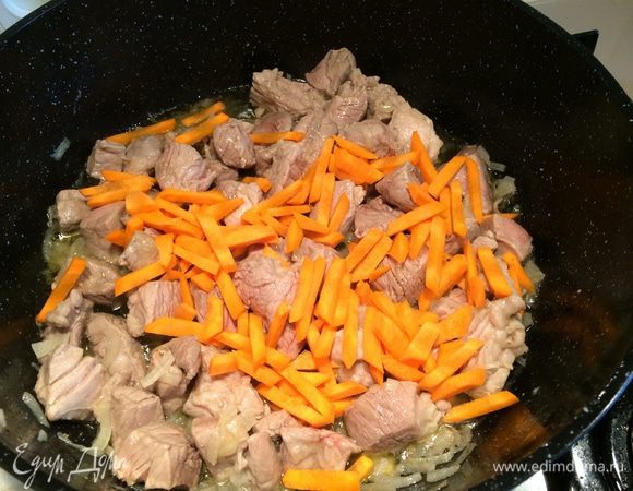 В чугунную сковородку или казанок влить подсолнечное масло и обжарить лук до золотистого цвета.  Затем добавить мясо и обжарить до появления румяной корочки. Добавить морковь и тушить 5-7 минут, не накрывая казан крышкой.
