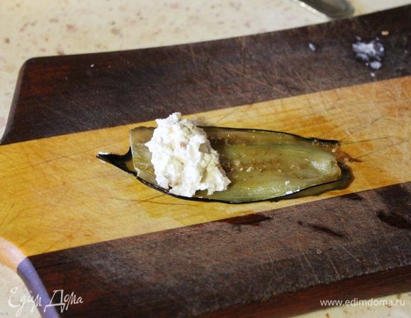 Теперь берем две пластинки баклажана, на край кладем начинку из сыра и сворачиваем рулетом.
