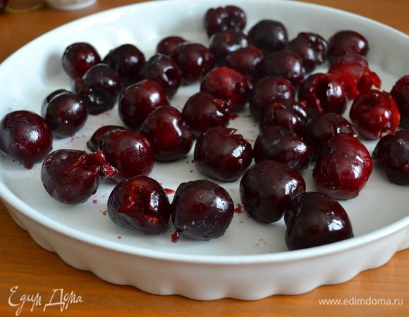 Керамическую форму для выпечки (28–30 см) смазать сливочным маслом и выложить ягоды. Оставить несколько ягод с хвостиком, чтобы украсить ими верх клафути.