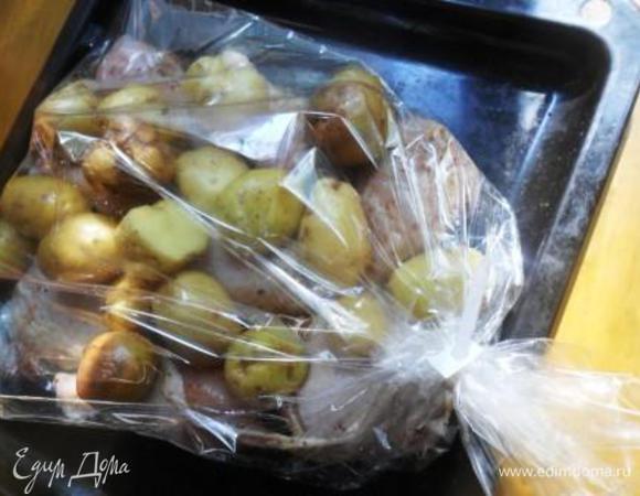 Выложить картофель на курицу в пакет для запекания и поместить в разогретую духовку.
Запекать около часа при 200С.