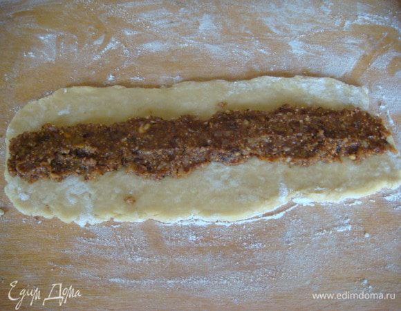 Раскатываем тесто и распределяем по центру начинку, внахлест тесто в рулетик.
Делим на 6 равных частей.