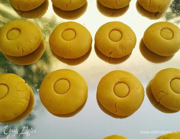 Разделить тесто на 14 одинаковых кусочков, скатать шарики, выложить их на противень и каждый шарик слегка  придавить ладошкой.
В оригинале в середине каждого шарика делают углубление пальцем для того, чтобы в конце заполнить это углубление яичным желтком.
Я этого не делала.