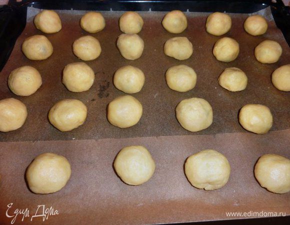 Включить духовку на 175 градусов. Размять руками кусочки теста в лепешку, положить в центр немного начинки и сформировать шарик.