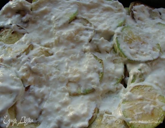 В сметану добавить 3-4 измельченных зубчика  чеснока, подсолить. Выложить на кабачки.