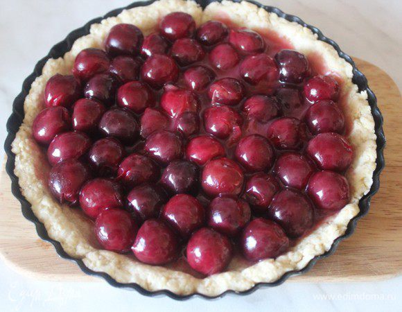 Достать форму с тестом из холодильника, сделать на тесте частые наколы вилкой и отправить в предварительно разогретую до 180 градусов духовку на 15 минут. Затем достать, выложить сверху начинку.