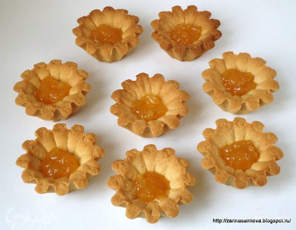 На дно остывших корзинок выложить по чайной ложке повидла. 