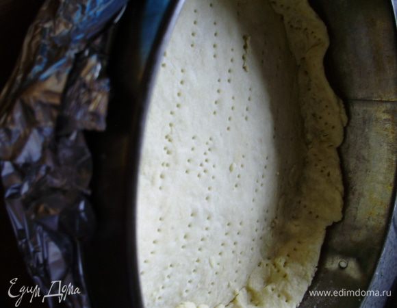 Разогреть духовку до 180 С. Присыпать стол мукой, раскатать тесто и поместить его в форму (предварительно смазанную маслом), сформировать бортики. Тесто проколоть вилкой, не забыть и про бортики. Поставить в духовку на 12 мин.