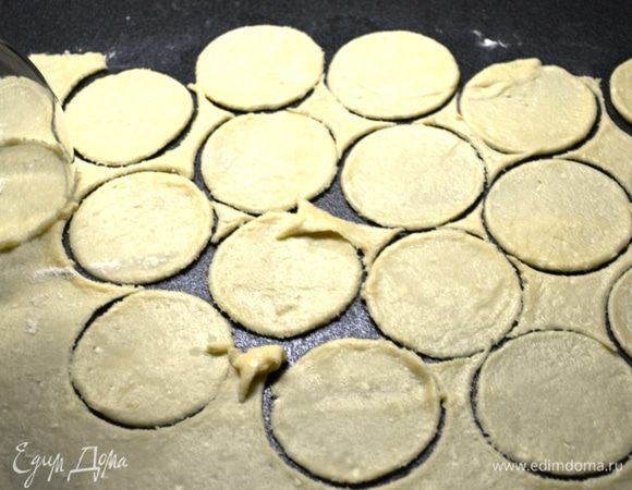 Из каждой части раскатываем круг толщиной 2-3 мм.
Вырезаем на круге кружочки стаканом (диаметр меньше брать не стоит, поскольку готовое печенье будет суховатое).