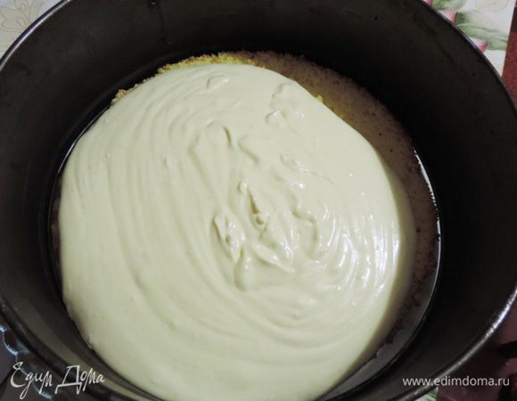 Кладем на блюдо бисквитный корж. Его заключаем в кольцо диаметром 23см. Центрируем корж, чтоб расстояние до формы везде было одинаковым. 
Теперь выкладываем примерно треть крема и равномерно разравниваем, заполняя зазор между стенкой формы и бисквитом.