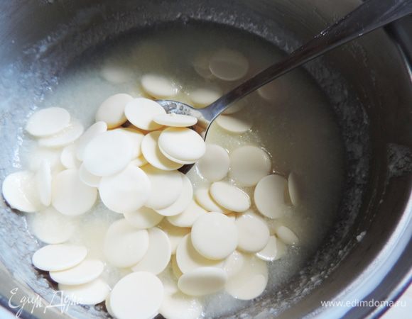 Утром приступим к приготовлению глазури. Заранее замачиваем желатин и даем ему набухнуть.
В небольшую кастрюльку или ковшик складываем сливки и кондитерскую глюкозу, доводим смесь практически до кипения. Добавляем сухое молоко и перемешиваем до однородности.
Снимаем смесь с огня и добавляем белый шоколад (у меня белая кондитерская глазурь). Перемешиваем, пока шоколад полностью на расплавится.