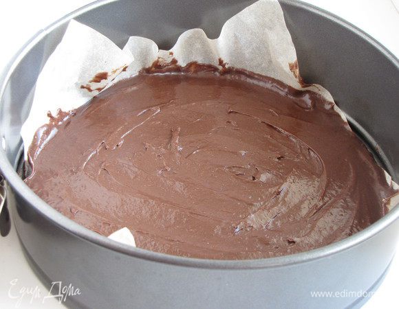 Выложить тесто ровным слоем на дно формы (диаметр 20-22 см), выстеленной бумагой.