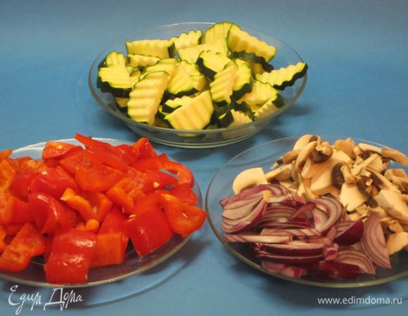 Лук нарезать дольками, цукини - полукружками, сладкий перец - крупными кусочками, грибы - ломтиками.