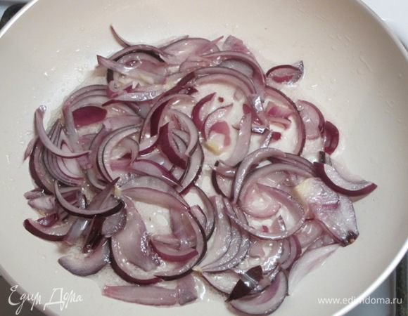 В глубокой сковороде разогреть 2 столовые ложки оливкового масла и обжарить лук.
