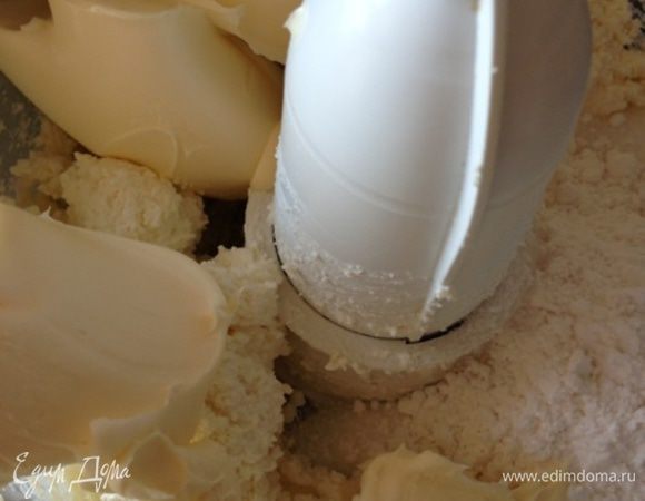 Поставим духовку разогреваться до 175 градусов. А сами займемся сырным слоем.
Измельчим творог до однородности при помощи кухонной техники. В рецепте было указано «жирный творог». Я брала обыкновенный (не пастообразный) 9%.
Добавим маскарпоне, кукурузный крахмал, сахар, ванильный сахар и хорошенько взобьем.  
