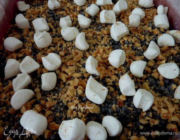 Вытащить брауни из духовки и посыпать оставшимися каплями шоколада ( 100 гр ) сверху посыпать орехами и маршмело .  Запечь дополнительно 5 минут . 
