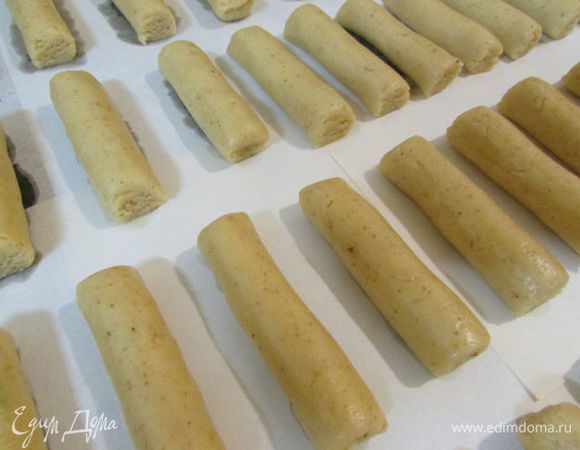 Выложить брусочки на противень, застеленный пекарской бумагой. Отправить в разогретую духовку (180 градусов) и выпекать 10 минут. Готовое печенье  должно оставаться белыми. Дать остыть.