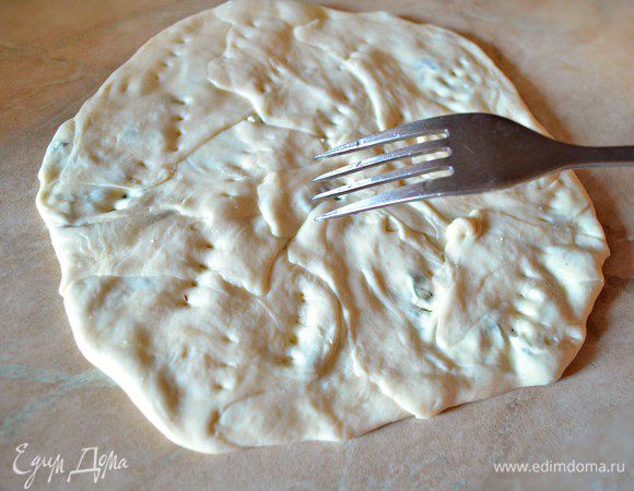 Слегка пройдите скалкой по поверхности или примните руками. На подготовленной к выпеканию паланице вилкой сделайте несколько наколов.