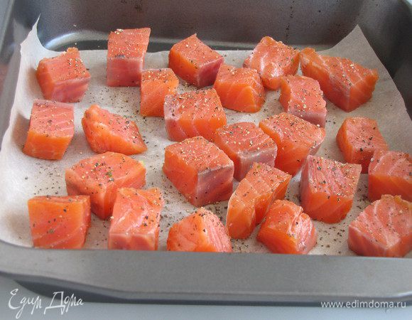 Разогреть гриль в духовке. Нарезать филе лосося кубиками со стороной 3 см, посолить и поперчить. Переложить на противень, застеленный бумагой для выпечки, и поставить под гриль. Готовить 3-4 минуты до золотистой корочки. 
