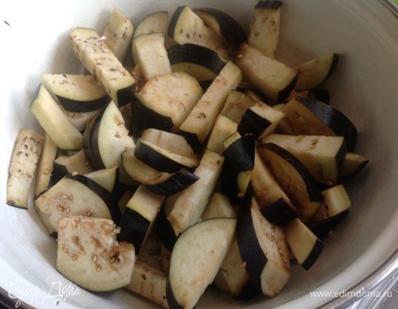 Разрежьте баклажаны вдоль, а затем ломтиками толщиной 5 мм. Положите в миску и посолите, отставьте на 30 мин. Затем промойте в холодной воде и тщательно отожмите лишнюю влагу.