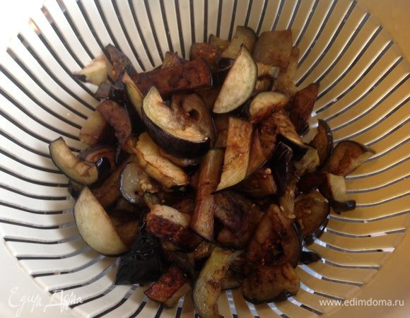 Разогрейте большую сковороду с оливковым маслом и в несколько приемов обжарьте баклажаны. Готовую партию выкладывайте в дуршлаг, чтобы стекло лишнее масло, и перекладывайте в широкую кастрюлю.