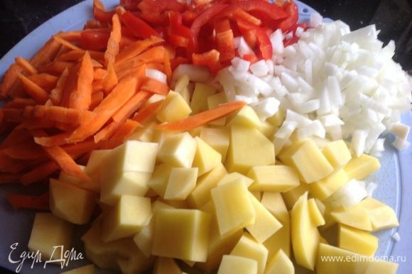 Очистите овощи. Лук нарежьте мелкими кубиками, морковь-соломкой, болгарский перец-полосками, картофель - средними кубиками.