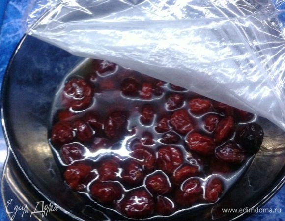 Замочить клюкву в коньяке. Поставить в холодильник на час. После этого откинуть клюкву на дуршлаг и слить коньяк в емкость. 