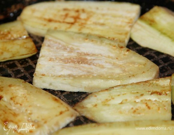 Сбрызгиваем поверхность сковороды маслом, выкладываем в один слой пластины баклажан и сбрызгиваем снова. Слегка обжариваем с обеих сторон.