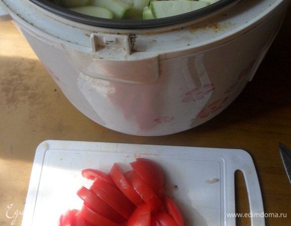 Вымыть кабачок и помидор, обсушить. Кабачок нарезать полукольцами. Выложить слоем на куриное филе.
Помидор нарезать. 