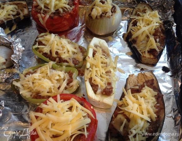 Сыр натрите на крупной терке. Достаньте овощи из духовки, посыпьте сыром и поставьте обратно еще на 10-15 минут.