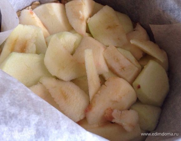 Тем временем яблоки очистить и нарезать тонкими дольками.Вынуть форму и распределить яблоки по поверхности теста. 