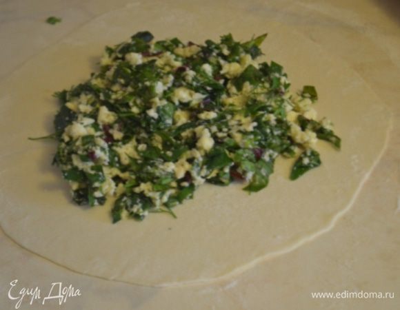 Каждый кусок теста раскатать как можно тоньше в круглую лепешку, в центр положить по 2 большие ложки начинки.