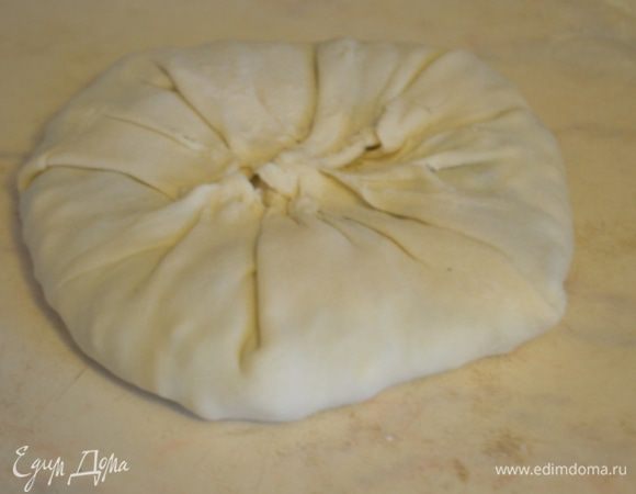 Края защипнуть в центре, получится как бы мешочек и расплющить аккуратно или скалкой или просто придавить рукой.