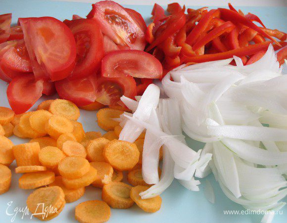 Очистить овощи. Два средних луковицы нарезать тонкими перьями, морковь - кружочками, сладкий перец - полосками, помидоры - дольками.