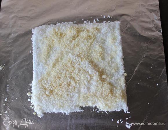 В это время насыплем на фольгу или пергамент кокосовую стружку и измельченный очищенный миндаль. 