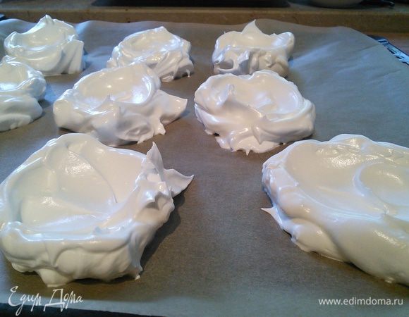 Формируем Павлову: для этого столовой ложкой выкладываем тесто на противень с бумагой для выпечки, надавливая ею по середине, чтобы образовалось лёгкое углубление.