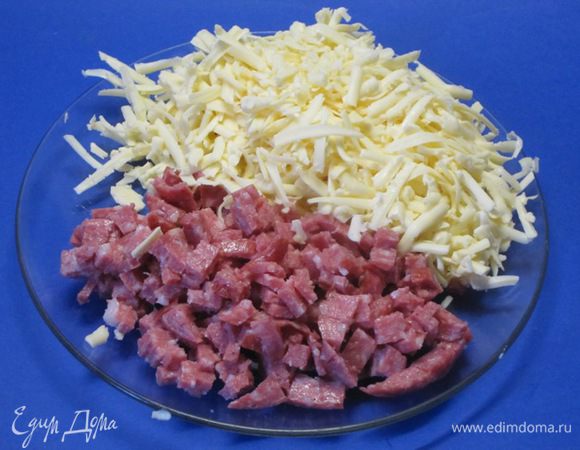 Колбасу нарезать небольшими кубиками. Сыр натереть на крупной терке.