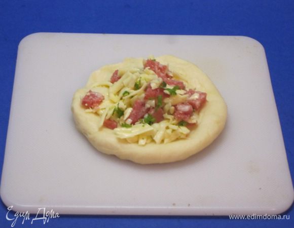 Каждый кусочек теста размять в небольшую лепешку. Выложить начинку.