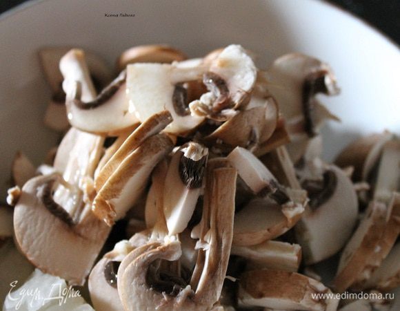 Разрезать каждый гриб пополам, а потом тонкими пластинками. Сложить к луку в сковородку, добавить 3 ст.л. растительного масла. Обжарить до слегка золотистого цвета.