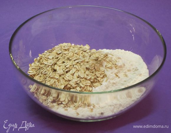 В другой миске просеять 175 грамм  муки. Всыпать разрыхлитель и хлопья "Геркулес" без варки, можно взять мюсли.