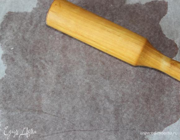 Поставить разогреваться духовку до 160 градусов. 
Достать тесто и раскатать его между слоем пищевой пленки (внизу) и пергамента (сверху) в тонкий пласт больше диаметра формы. 
