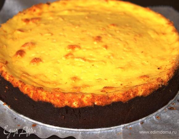 Вылить массу на основу и поставить в духовку на 20 минут.
Уменьшить температуру до 160 градусов и выпекать еще минут 30. Выключить духовку и дать пирогу постоять еще минут 15. 
Затем достать творожник из духовки и полностью остудить. 
Аккуратно снять обод формы, проведя ножом по диаметру. 
Желательно выдержать творожник в холодильнике хотя бы пару часов перед подачей (так он станет еще вкуснее и снять его с пергамента не составит труда)!! 
У меня стоял ночь, а с утра от него невозможно было оторваться!! 