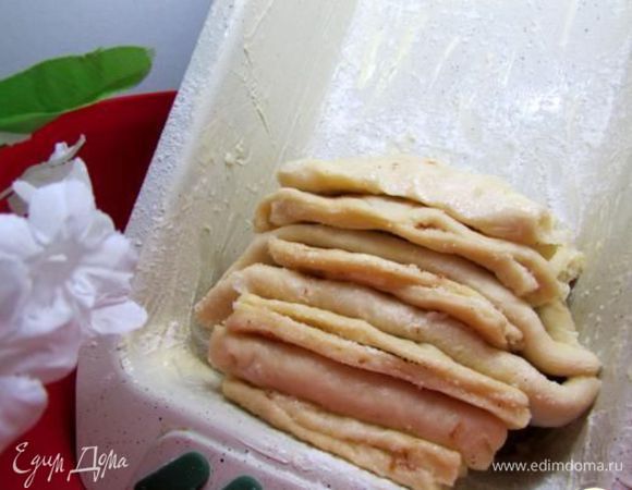 Форму для кекса смазать маслом, присыпать мукой, поместить форму в любую чашу так, чтобы форма стояла вертикально под наклоном. Подготовленные таким образом “слои” теста выкладывать в форму свободно, не прижимая слои друг к дружке, чередуя сгиб – один слой сгибом вверх, другой сгибом вниз.