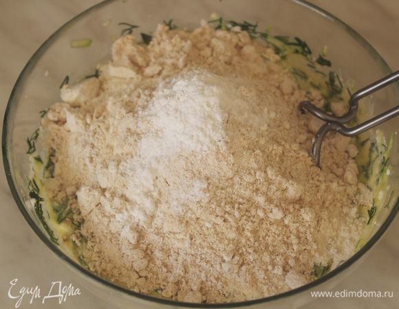 Добавить растопленное сливочное масло, оба вида муки и разрыхлитель, посолить и перемешать.