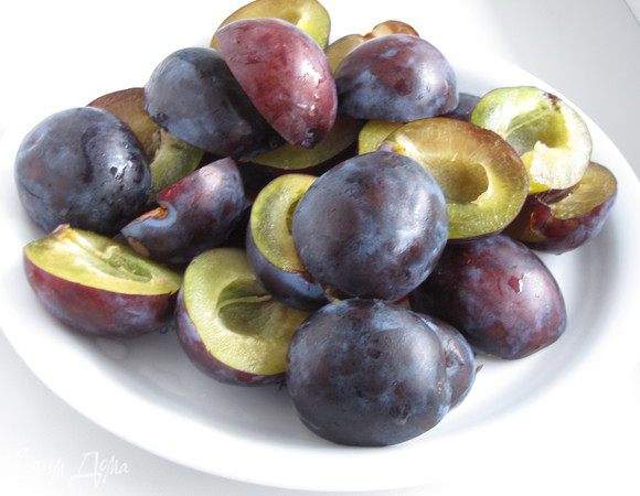 Сливы разрезать на две части и удалить косточку.