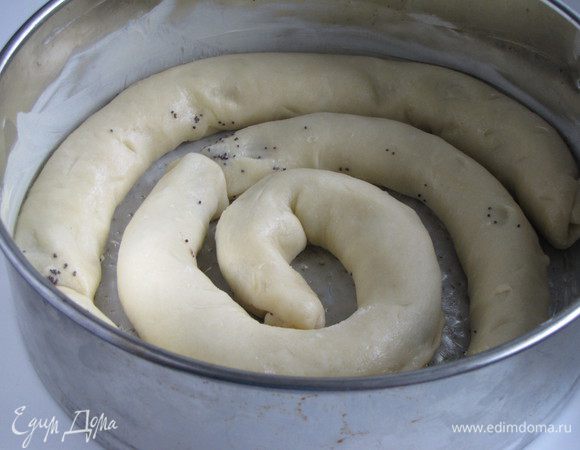 Завернуть начинку в "колбаски" и выложить в форму (d 28 см), смазанную сливочным маслом, формируя спираль и оставляя между витками свободные места для слив. 