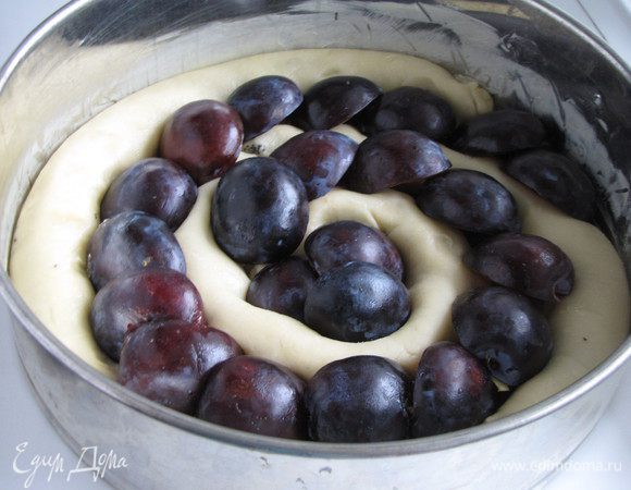 Заполнить половинками слив свободные места, накрыть пирог полотенцем и оставить на пол часа для подъема.