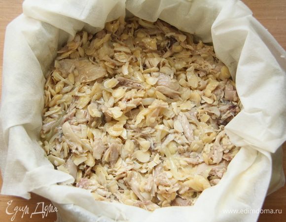 Выложить половину начинки. Закрыть четырьмя листами фило, смазанными маслом. Выложить оставшуюся часть начинки.