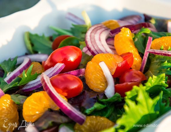 Полукольцами нарежем красный лук, помидорки - на половинки. Зелёный лук, укроп и петрушку мелко накрошим. Смешаем это с набором зелени и мандаринами. Не забудьте из консервированных мандаринов слить жидкость. Но не выливайте всю, оставьте 2-3 столовых ложки для заправки.